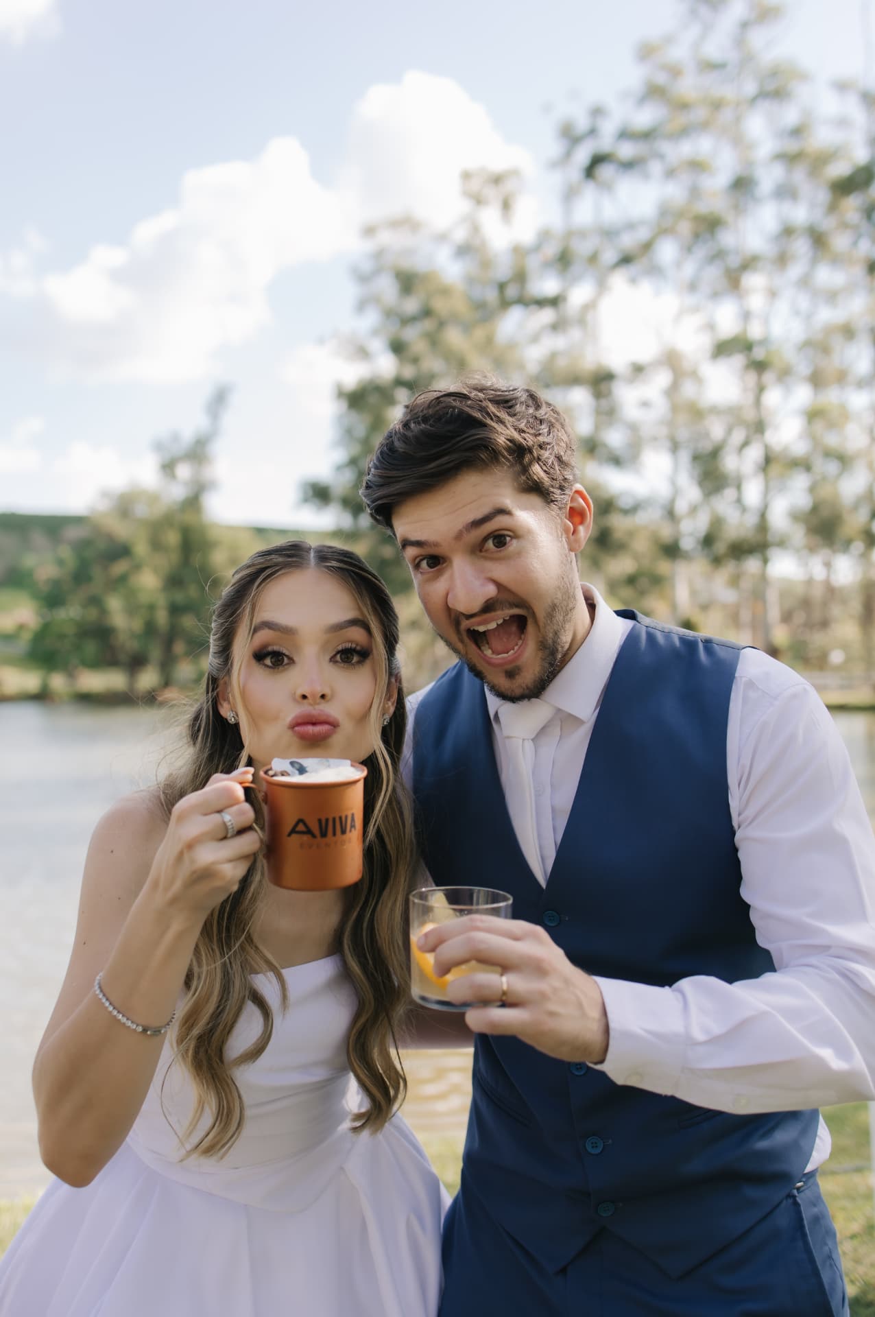 Casal celebra com bebidas em evento ao ar livre